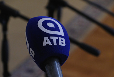 Микрофон телекомпании "АТВ" из Бурятии на фоне подставок для микрофонов