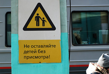 Безопасность детей на железной дороге. Предупреждающая надпись на фоне ребенка в окне вагона поезда