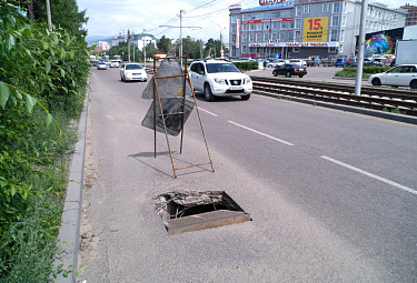 Провал на улице Сахьяновой в Улан-Удэ огорожен знаком. Лето 2023 года