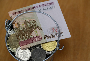 Российские деньги. Сторублевая купюра на ведерке с монетами