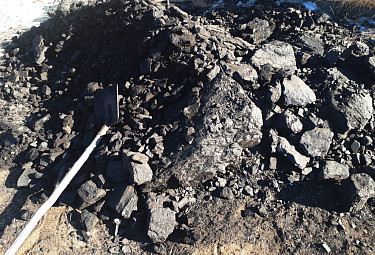 Совковая лопата и куча каменного угля на земле