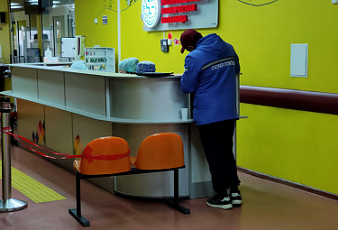 Больница. Работник "Скорой помощи" у стойки, отгороженной из-за коронавируса ленточками