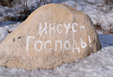Камень с христианской надписью "Иисус - Господь!" на фоне снега