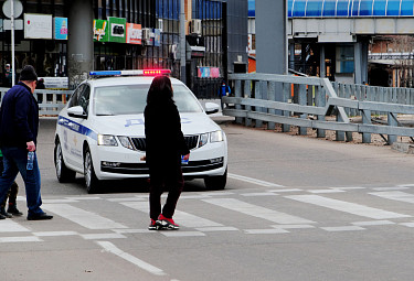 Дорожное движение. Полицейская машина пропускает людей на пешеходном переходе