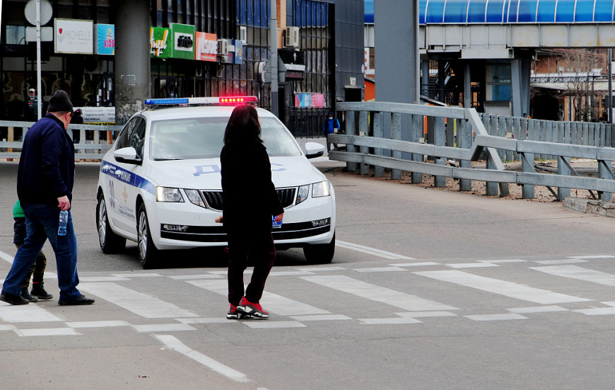 Дорожное движение. Полицейская машина пропускает людей на пешеходном переходе