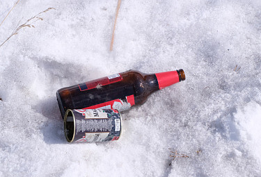 Бутылка и банка, выброшенные в снег