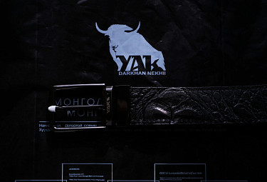 Монгольский кожаный ремень компании "Дархан нэхий" лежит на фирменном пакете компании