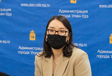 Тамара Юрьевна Булгутова на фоне растяжки улан-удэнской горадминистрации (2022 год)