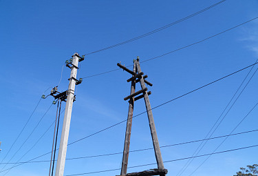 Развитие энергетики в Улан-Удэ. Новый бетонный электрический столб с проводами и старый деревянный - без проводов