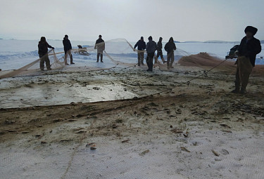 Рыбаки с сетью на берегу зимнего Байкала