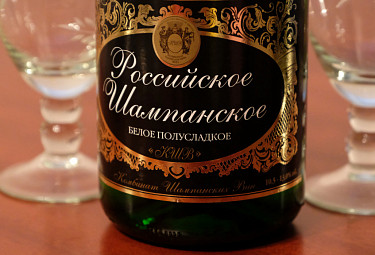 Бутылка шампанского на фоне бокалов
