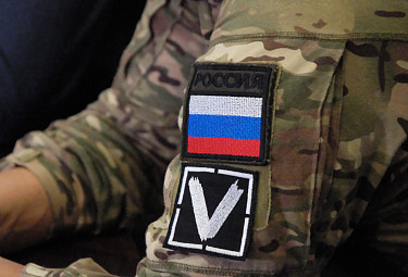 Символ "V", флаг России и название страны "Россия" на форме участника заседания на тему спецоперации на Украине (2022 год)