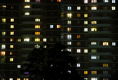Ночной Улан-Удэ. Многоэтажный дом со светящимися окнами и силуэт дерева