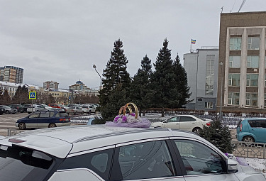 Белая свадебная машина на фоне здания правительства Бурятии с флагами на крыше. Улан-Удэ. Осень 2023 года
