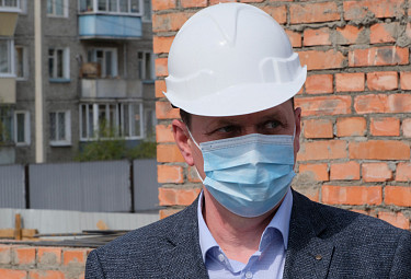 Улан-Удэ. Игорь Шутенков в маске и каске - у кирпичной стенки на стройке (2020 год)
