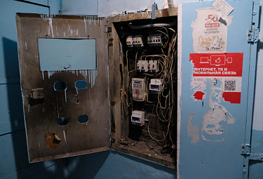 Старый грязный электрощит в подъезде многоэтажки - провода, электросчетчики, автоматы-предохранители