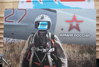 Российская армия. Пропагандистский щит с лицевым вырезом для фотографирующегося. В вырезе виден разрисованный гофрированный бок железнодорожного вагона