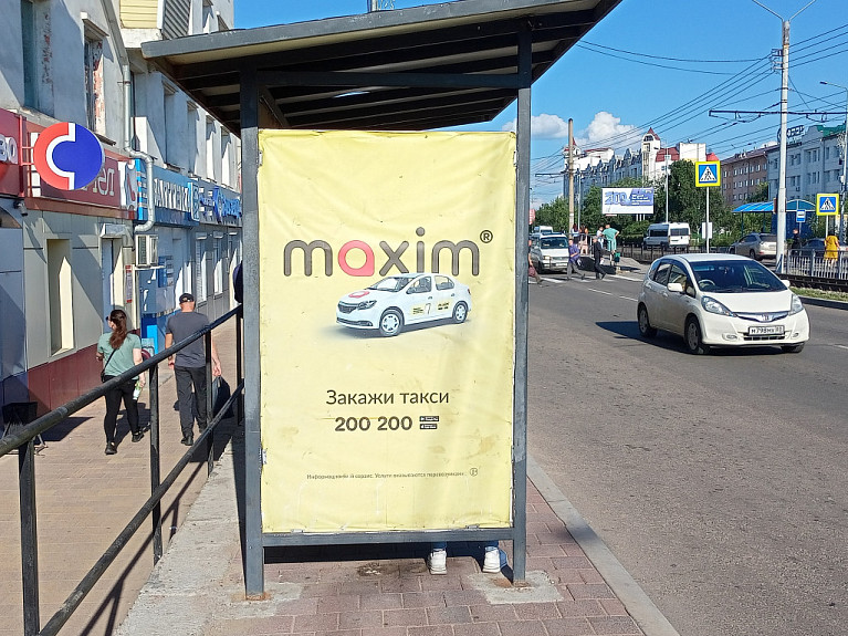 Реклама федеральной службы заказа такси maxim на остановке. Улан-Удэ. Улица Терешковой. 2023 год