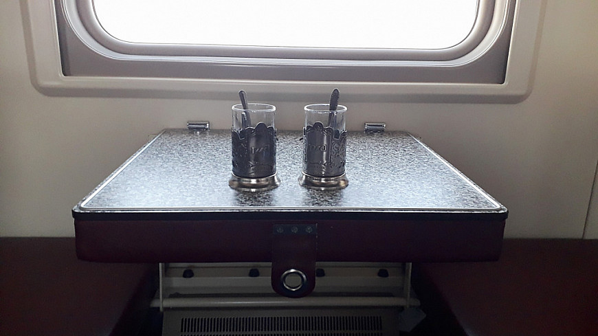Два стакана "РЖД" на столике в плацкартном вагоне