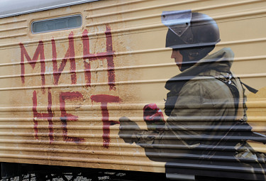 Разминирование. Пропагандистский плакат российской армии о саперах "Мин нет" на гофрированном боку армейского  железнодорожного вагона