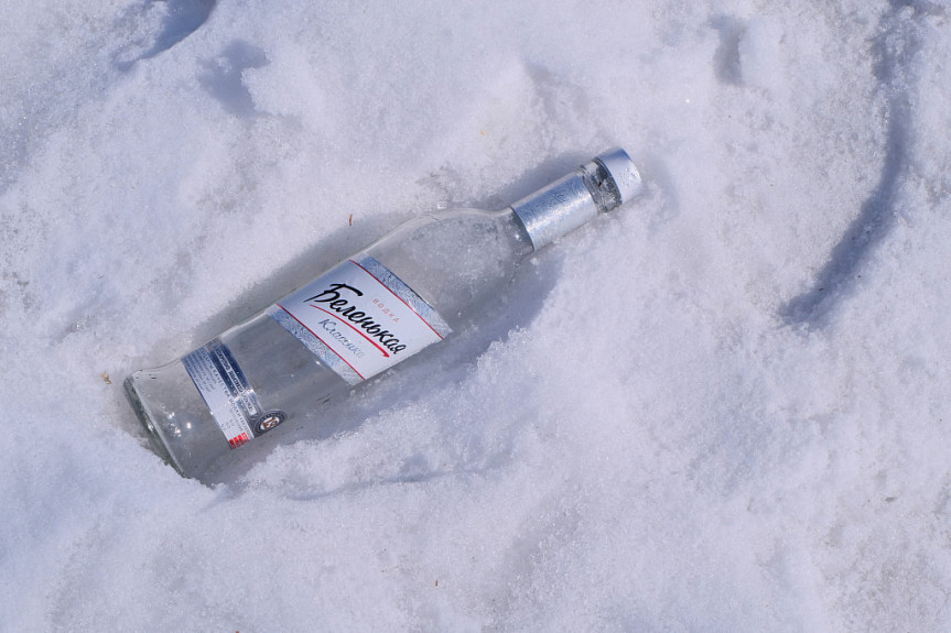 Бутылка виски, стоящая на покрытой снегом земле