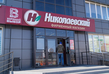 Бурятия. Покупатель заходит в фирменный магазин торговой сети "Николаевский" (Улан-Удэ, 2022 год)