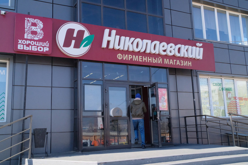 Бурятия. Покупатель заходит в фирменный магазин торговой сети "Николаевский" (Улан-Удэ, 2022 год)